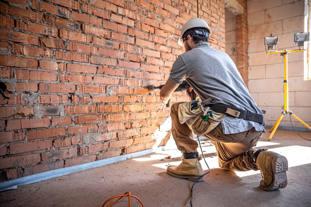 handyman-construction-site-process-drilling-wall-with-perforator